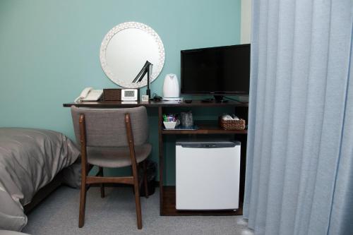 a desk with a chair and a computer and a mirror at Global Resort Miyajima View in Hatsukaichi