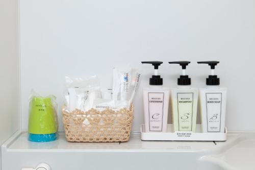 a shelf with four bottles oficating products on it at Global Resort Miyajima View in Hatsukaichi