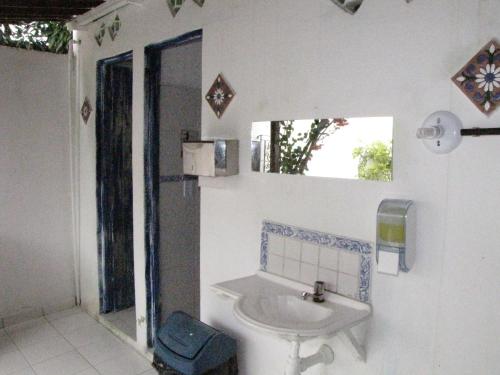 y baño blanco con lavabo y ducha. en Pousada Joãozinho Caminhador en Recife