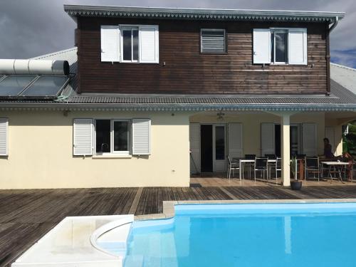 a house with a swimming pool in front of a house at La Pointe au Corail in Sainte-Rose