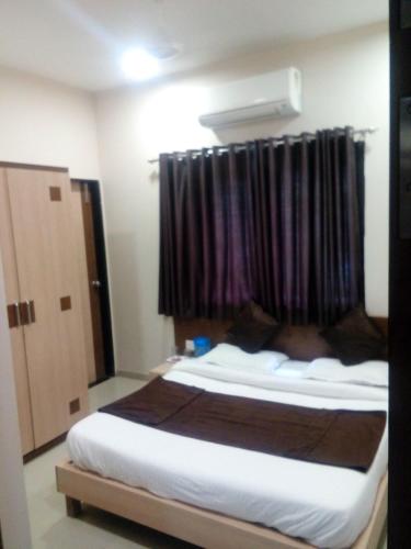 a bedroom with a large bed with a window at Hotel Midtown Inn in Trimbak