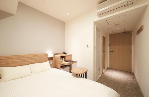 a bedroom with a white bed and a desk at Sotetsu Fresa Inn Tokyo Kinshicho in Tokyo