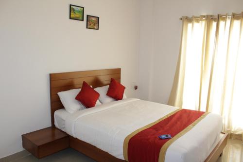 a bedroom with a large bed with red pillows at Sam's Terrace in Chikmagalūr