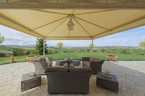 a large tent with couches and tables on a patio at Relais Il Margarito in Montefano
