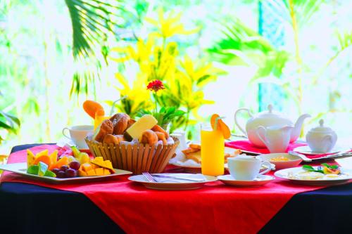 a table with a red table cloth with food on it at Mount View in Polonnaruwa