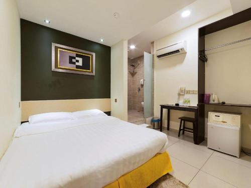a bedroom with a bed and a desk and a bathroom at One Avenue Hotel in Petaling Jaya