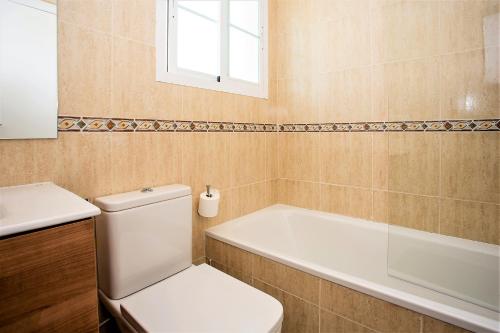 a bathroom with a toilet and a tub and a sink at Luxury Apartments with private swimming pool in Marbella