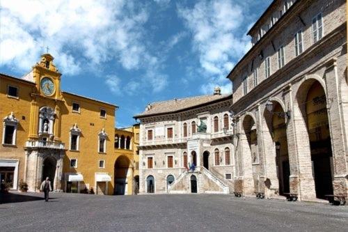 a group of buildings with a clock tower in the distance at La Stanza Di Alice in Ponzano di Fermo