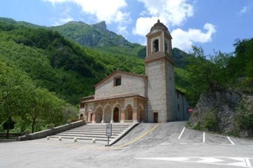 a church with a clock tower in a parking lot at La Stanza Di Alice in Ponzano di Fermo