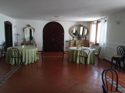 a dining room with two tables and a mirror at La dimora dei 5 sensi in Faiano