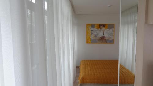 um quarto com uma cama e uma janela com cortinas brancas em Preila Holiday em Preila