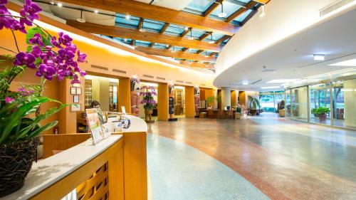 una hall di un edificio con fiori viola su un bancone di Luminous Hot Spring Resort & SPA a Luye