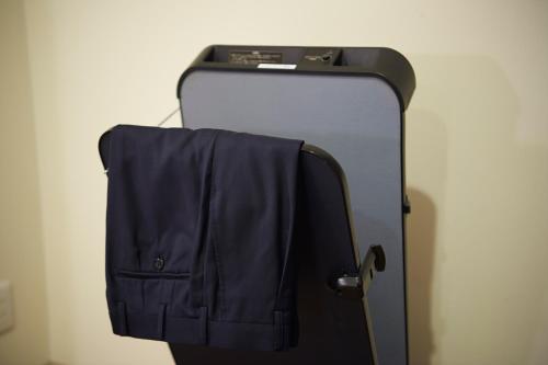 a suitcase with a blue jacket hanging on it at Sotetsu Fresa Inn Tokyo Kinshicho in Tokyo