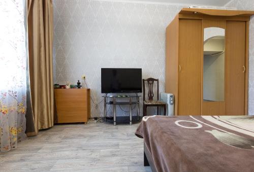 una camera con letto e TV su un tavolo di Apartment on Ploshchad Lenina 12/2 ad Astrakhan
