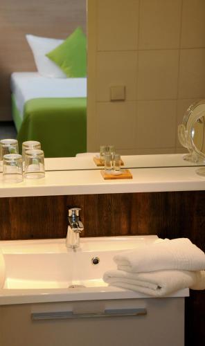 a bathroom with a sink and a mirror and a bed at Parkhotel Forsthaus in Tharandt