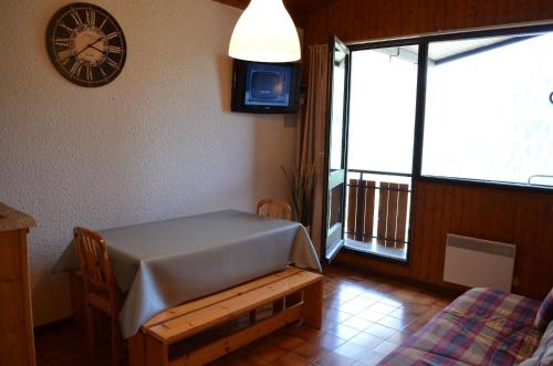 a room with a table and a clock on the wall at Hameau 4 saisons 124C - Appartement 5 pers - Chatel Reservation in Châtel