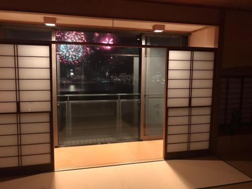 an open window with a view of a city at Atami Onsen Guest House Megumi 5 minutes walk from Atami Station in Atami