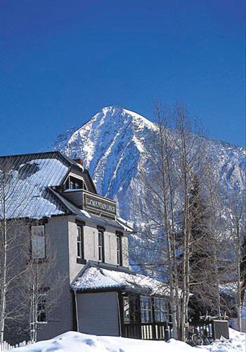 a building in front of a snow covered mountain at Elk Mountain Lodge in Crested Butte