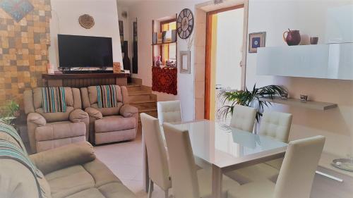 a living room with a table and a dining room at B&B Gi & Giò in Càbras