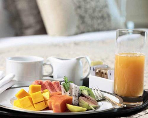 a plate of food and a glass of orange juice at Platinum Palace in Gurgaon