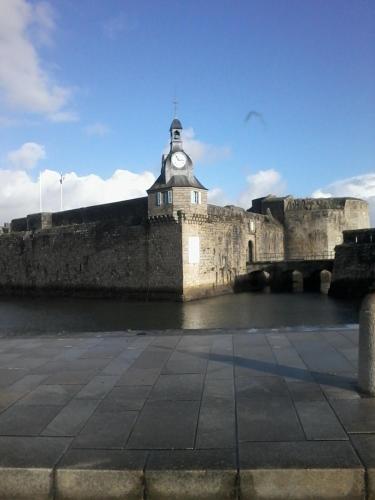 an old castle with a clock tower on top of it at les roches du Cabellou 150M de la mer in Concarneau