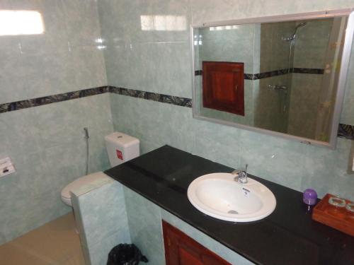 La salle de bains est pourvue d'un lavabo et d'un miroir. dans l'établissement Phouluang Hotel, à Phonsavan