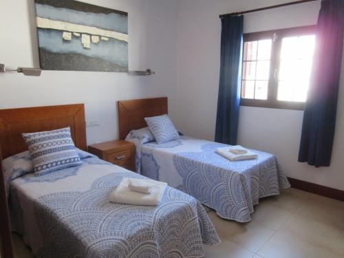 プラヤ・オンダにあるCasa La Barcaのベッド2台と窓が備わる客室です。