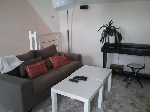 un salon avec un canapé et une table dans l'établissement chambre et salon vidéo, à Marzy