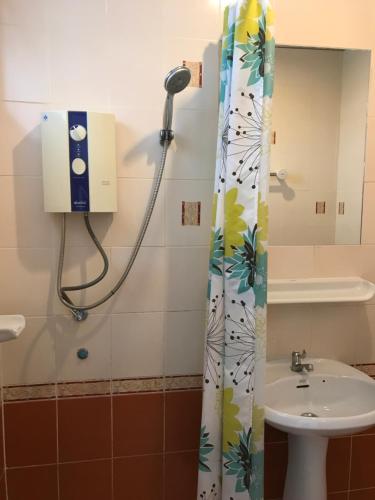 ホアヒンにあるBaan Pak I-Un Hua Hinの洗面台付きの浴室のシャワーカーテン