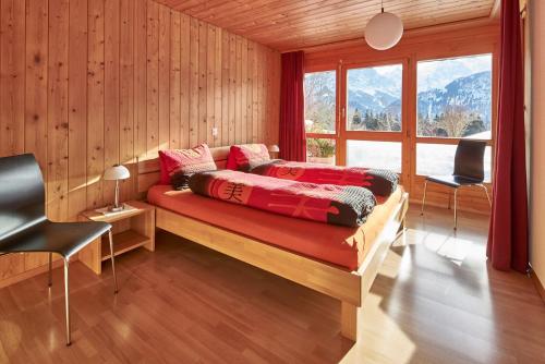 a bedroom with a bed with red sheets and a window at Ferienwohnung Leuweli in Hasliberg