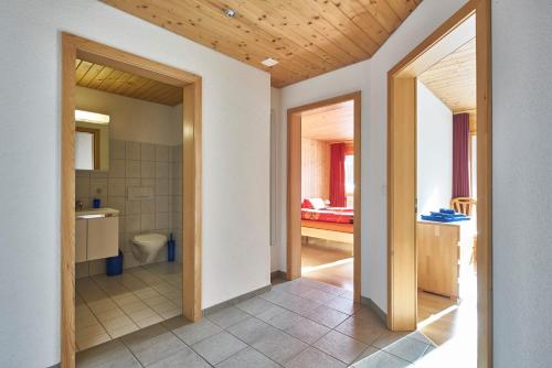 einen Flur mit einem Bad mit WC und Waschbecken in der Unterkunft Ferienwohnung Leuweli in Hasliberg