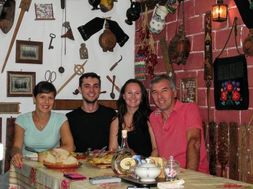 a group of people sitting at a table with food at Vila Milenovic Rajacke Pivnice in Rajac