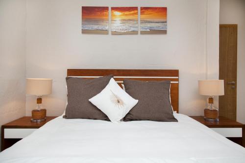 a bedroom with a white bed with two lamps at Les 2 canons in Flic-en-Flac