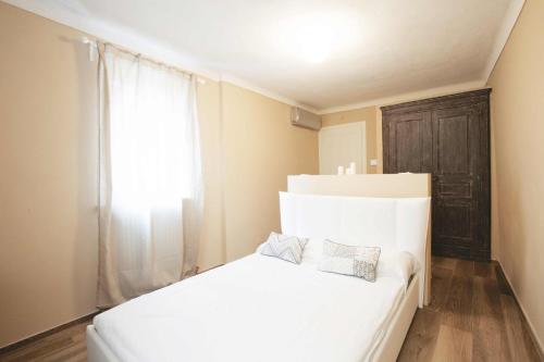 - un lit blanc dans une chambre avec fenêtre dans l'établissement Dimora della Rocca, à Costigliole dʼAsti