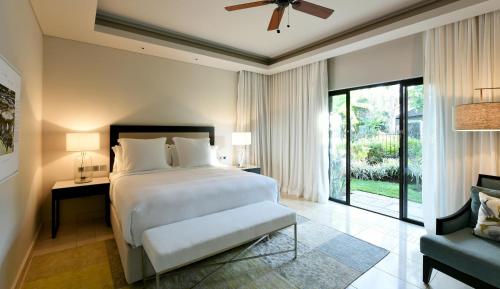 a bedroom with a large white bed and a window at Four Seasons Resort Mauritius at Anahita in Beau Champ