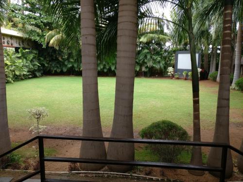 a view of a park with palm trees at Hotel Hampi International in Hospet