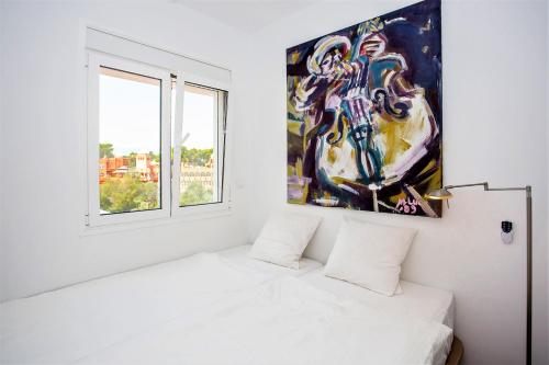 a white bedroom with a painting on the wall at Luxury Apartments with private swimming pool in Marbella