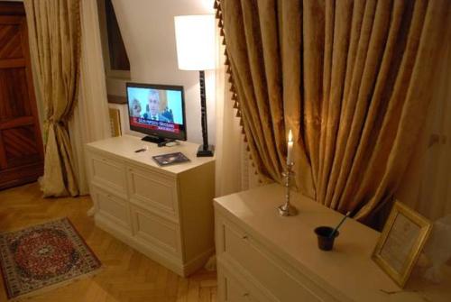 a living room with a tv and a bed at Grand Boutique Hotel in Bucharest
