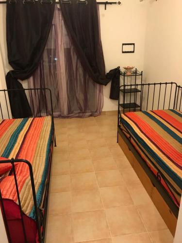 two beds in a room with a tile floor at Oriental Dary in Saidia 