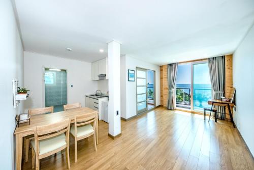 a kitchen and dining room with a table and chairs at Jeju Aurum in Seogwipo