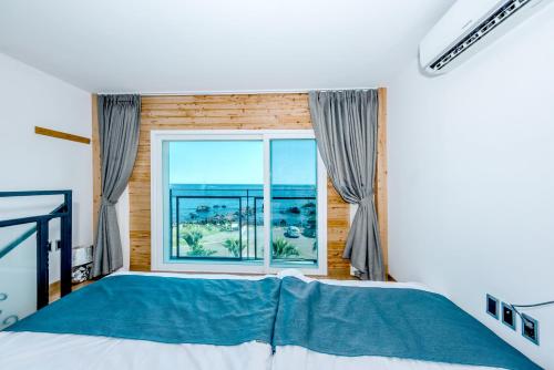 a bedroom with a bed and a large window at Jeju Aurum in Seogwipo