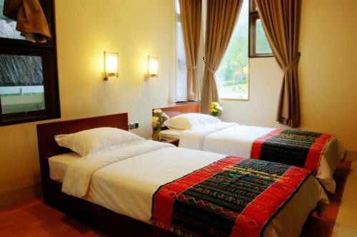 a bedroom with two beds and a window at Taman Simalem Resort in Tongging