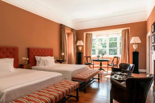 a hotel room with two beds and a table and chairs at Villa della Pergola Relais et Chateaux in Alassio