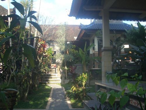 a house with a garden with trees and plants at Bagus Homestay in Ubud