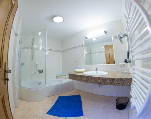a bathroom with a tub and a sink and a shower at Der Schwendterwirt in Schwendt