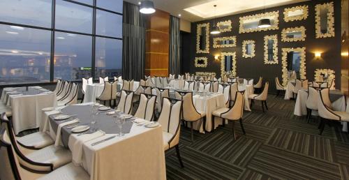 a dining room with white tables and chairs at Coastlands Umhlanga Hotel and Convention Centre in Durban