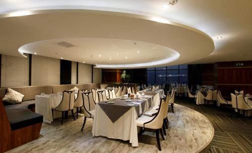 a dining room with white tables and chairs at Coastlands Umhlanga Hotel and Convention Centre in Durban