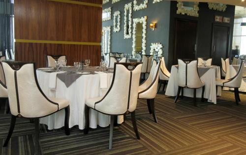 a dining room with white tables and chairs at Coastlands Umhlanga Hotel and Convention Centre in Durban
