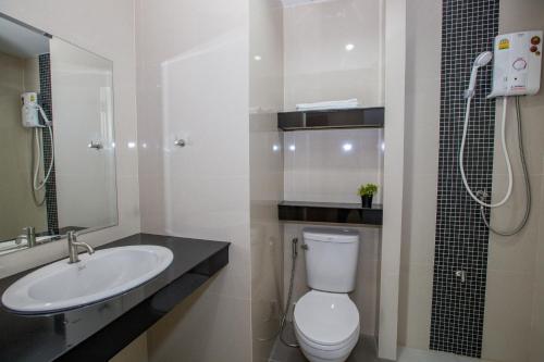 a bathroom with a toilet and a sink and a shower at Charisma Residence in Rayong