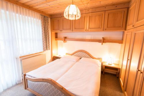 een slaapkamer met een bed en een kroonluchter bij Golfappartements in Bad Gastein